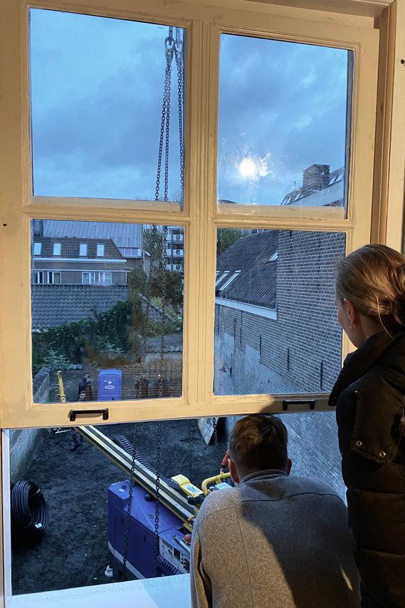Marloes en Hidde-Jan kijken naar het tillen van de boorapparatuur over hun huis