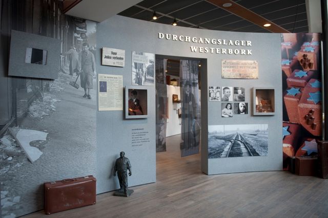 Een muur met foto's en krantenartikelen uit de Tweede Wereldoorlog in Museum Kamp Westerbork