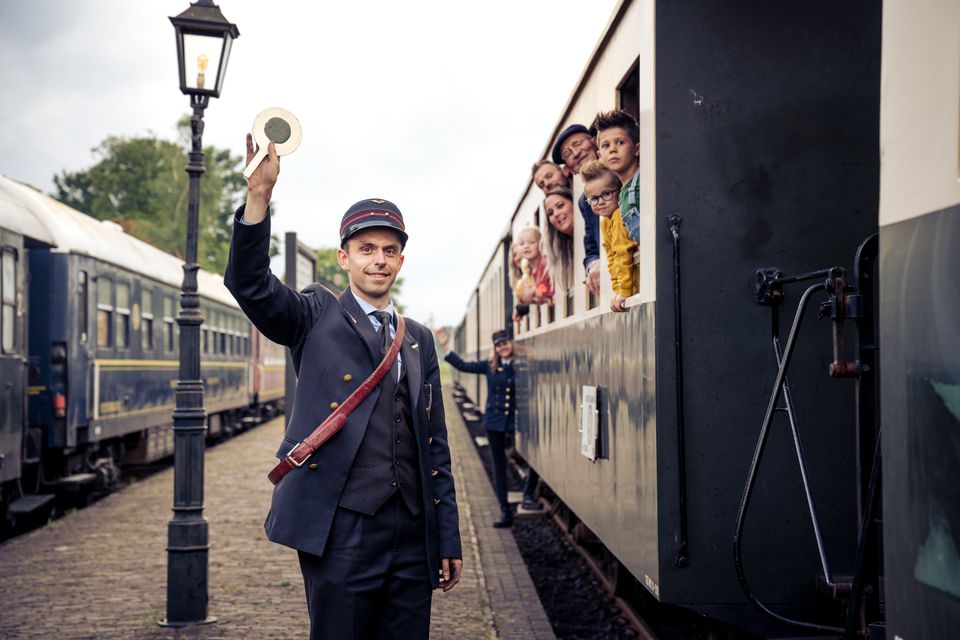 Conducteur buiten de trein geeft sein voor vertrek -  De Veluwsche Stoomtrein Maatschappij