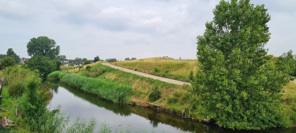 Fort van Hoofddorp vanaf de wegkant zicht op het de groene heuvel waar het fort onder ligt.