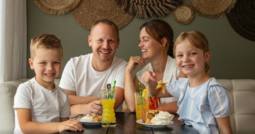 Martin en Selina Kalkhoven samen met hun kinderen aan de eettafel waar eten en drinken opstaat.