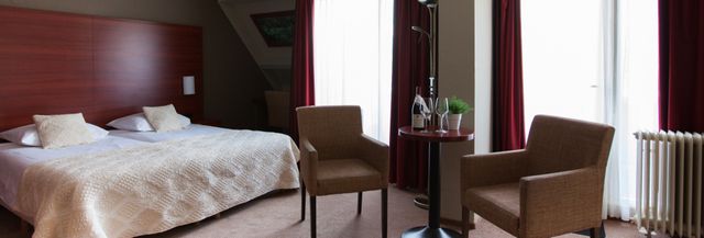 Hotelkamer met bed, tafel en stoelen in hotel De Oringer Marke in Odoorn.