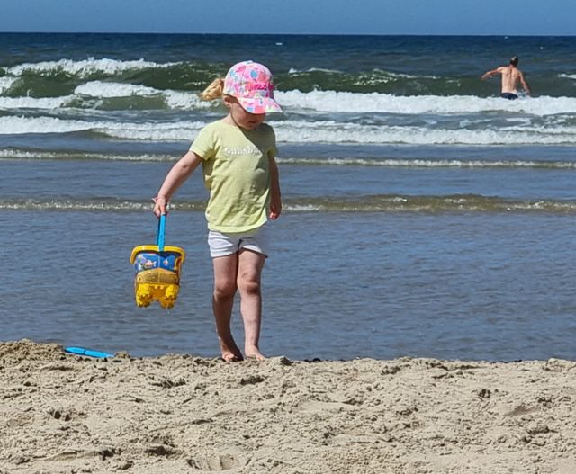 Kind op strand Vlieland met schepje