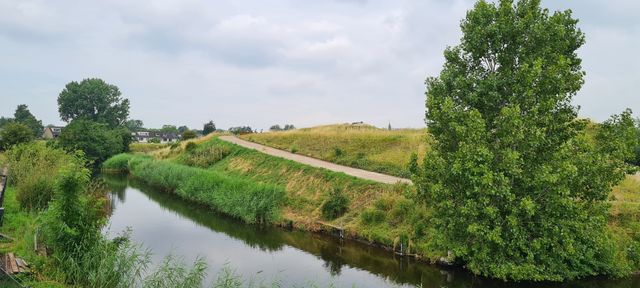 Fort van Hoofddorp vanaf de wegkant zicht op het de groene heuvel waar het fort onder ligt.