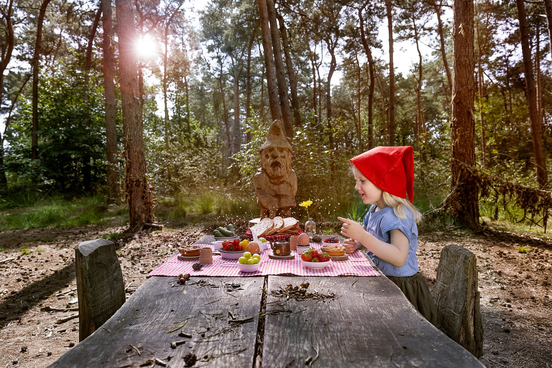Een meisje aan een tafel die een kabouterlunch aan het eten is.