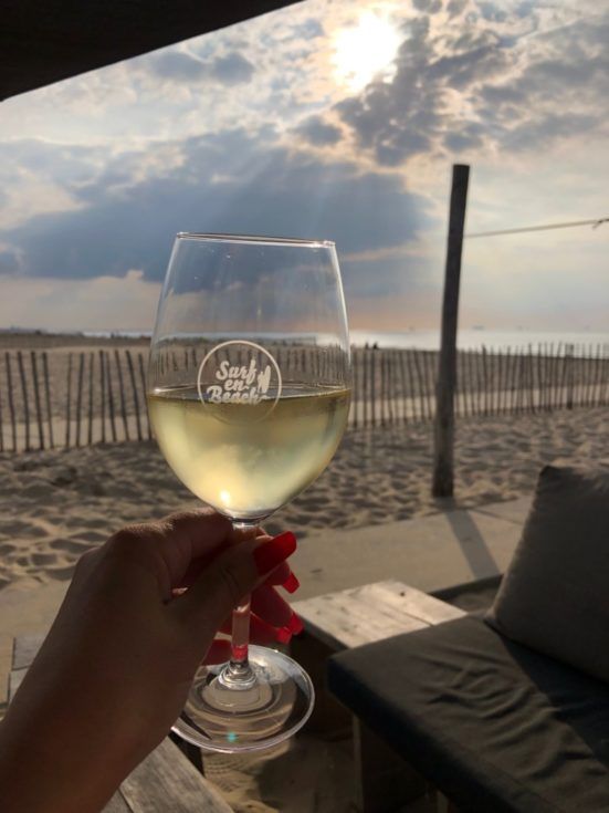 Glas wijn met uitzicht over zee in Katwijk.