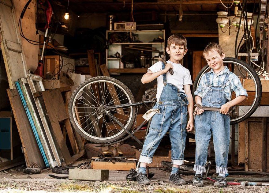 Twee jongens met gereedschappen voor een fietsenmakerij