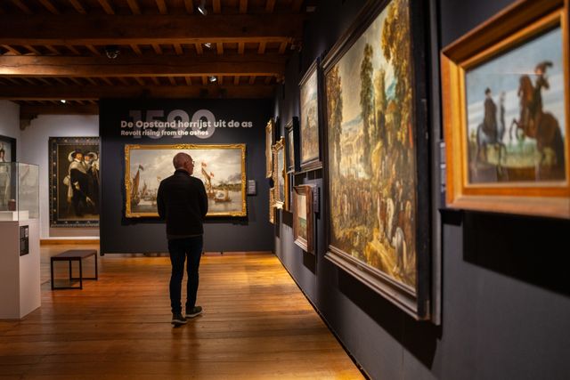 Meneer bekijkt schilderijen in het Museum Prinsenhof Delft