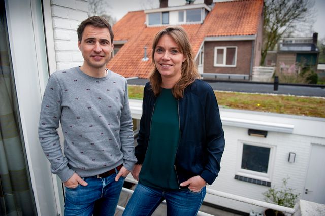 Foto van een man en vrouw met op de achtergrond een groen dak