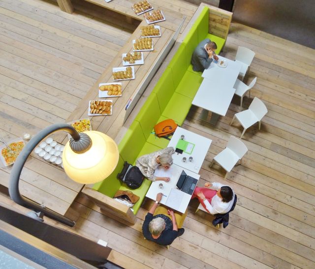 Een luchtfoto binnen in de Dutch Innovation Factory. Er zitten mensen te werken aan de tafels
