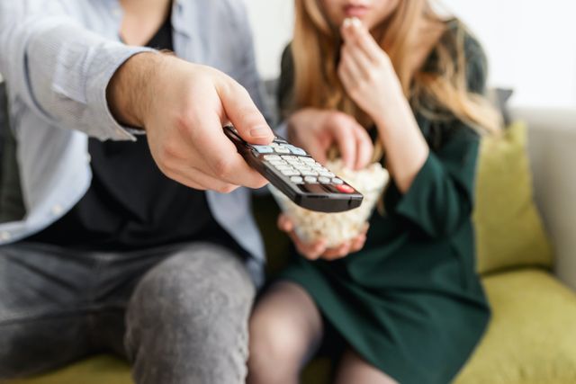 Two people with focus on a remote