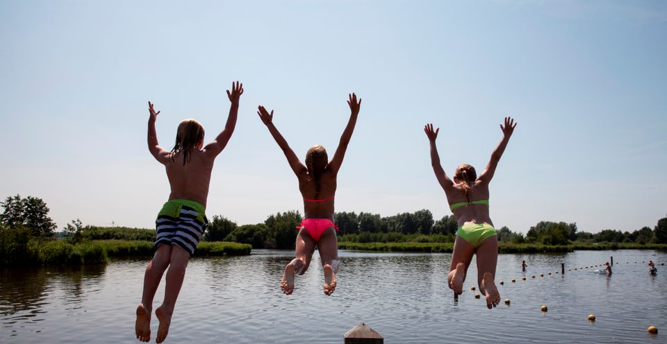 Drie kinderen springen in het water