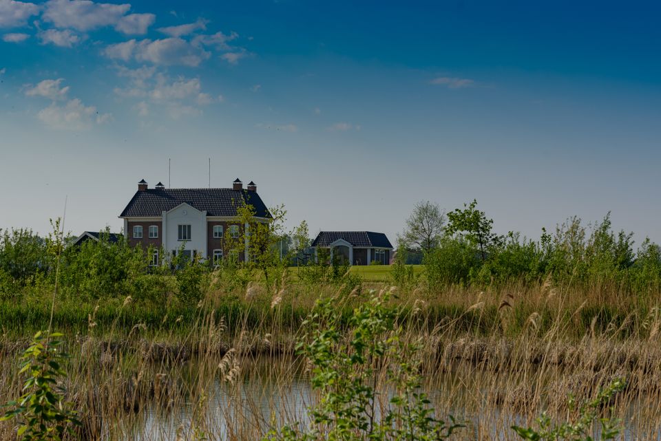 Landgoedhuis in de Wellerwaard aan het water in de Noordoostpolder, Flevoland