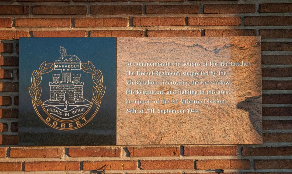A plaque commemorating the efforts of The Dorsetshire Regiment on the wall of the Westerbouwing restaurant on the embankment.