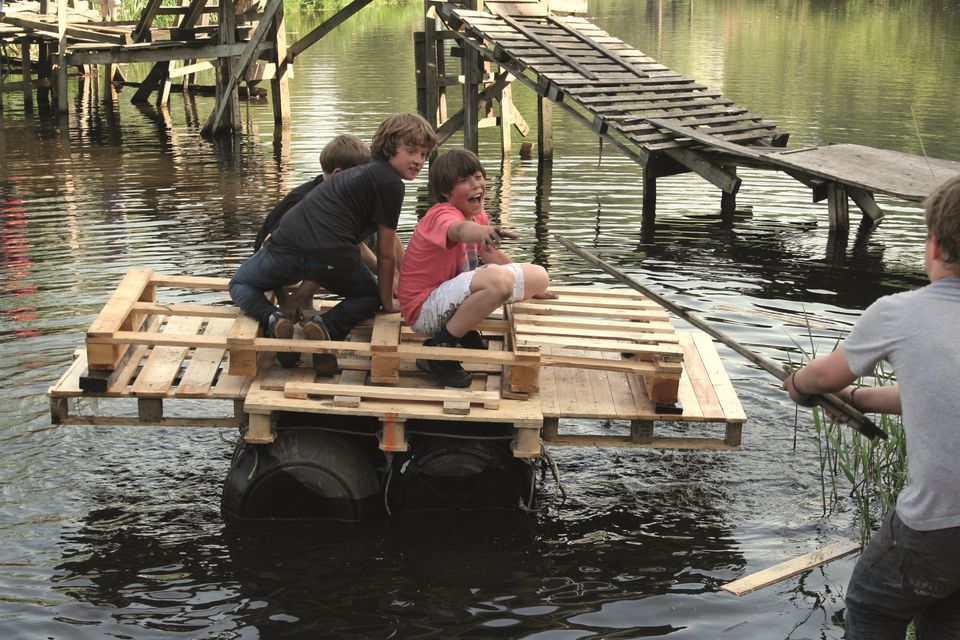 Kinderen die op een zelfgemaakt vlot op het water bij Het Kinderparadijs in Purmerend.