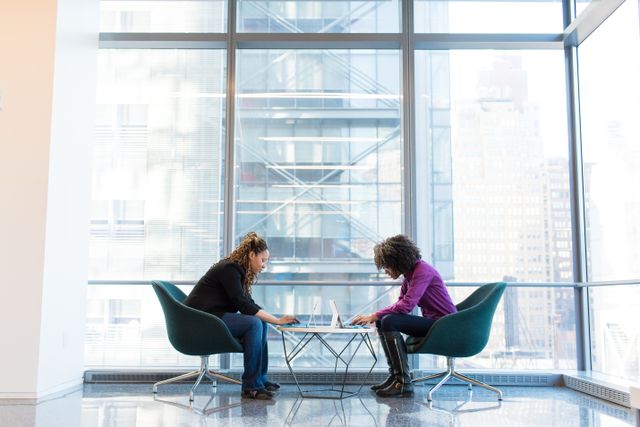Two women working in a corporate building.