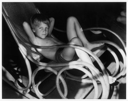 zwartwit foto jongen in schommel stoel