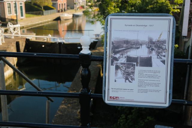 Foto van het informatiebord van de sluis. Op de achtergrond is de sluis uit 1917 te zien.