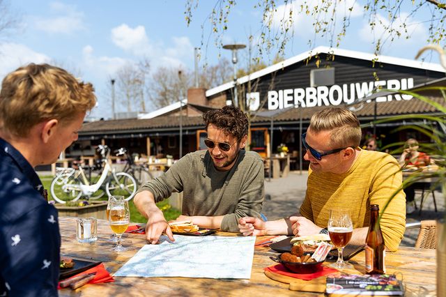 Fietsers pauzeren bij Brabants Fietscafé met een fietskaart