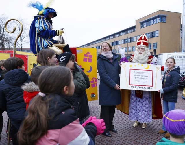 Sinterklaas en de directeur van Museum Hilversum laten de voucher zien