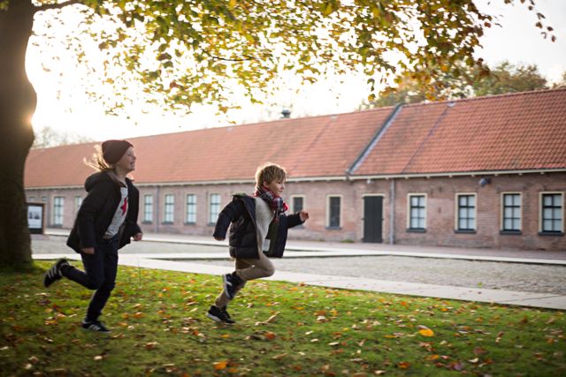 Kinderen rennen over het gras met het Gevangenismuseum op de achtergrond.