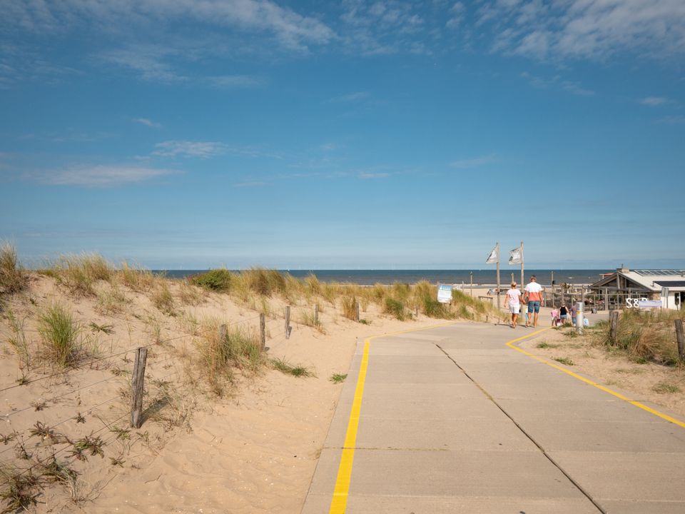 Strandopgang met bezoekers bij Boulevard Zeezijde nummer 9 in Katwijk aan Zee, met op de achtergrond strandpaviljoen Surf en Beach.
