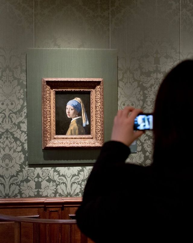 Meisje neemt foto van het schilderij in het Mauritshuis in Den Haag