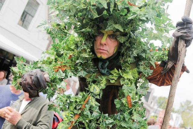 een man verkleed als een boom, hij heeft groene strepen op zijn gezicht
