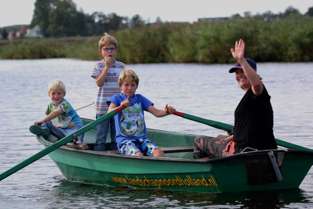 Kinderen in een roeiboot van Landschap Noord-Holland