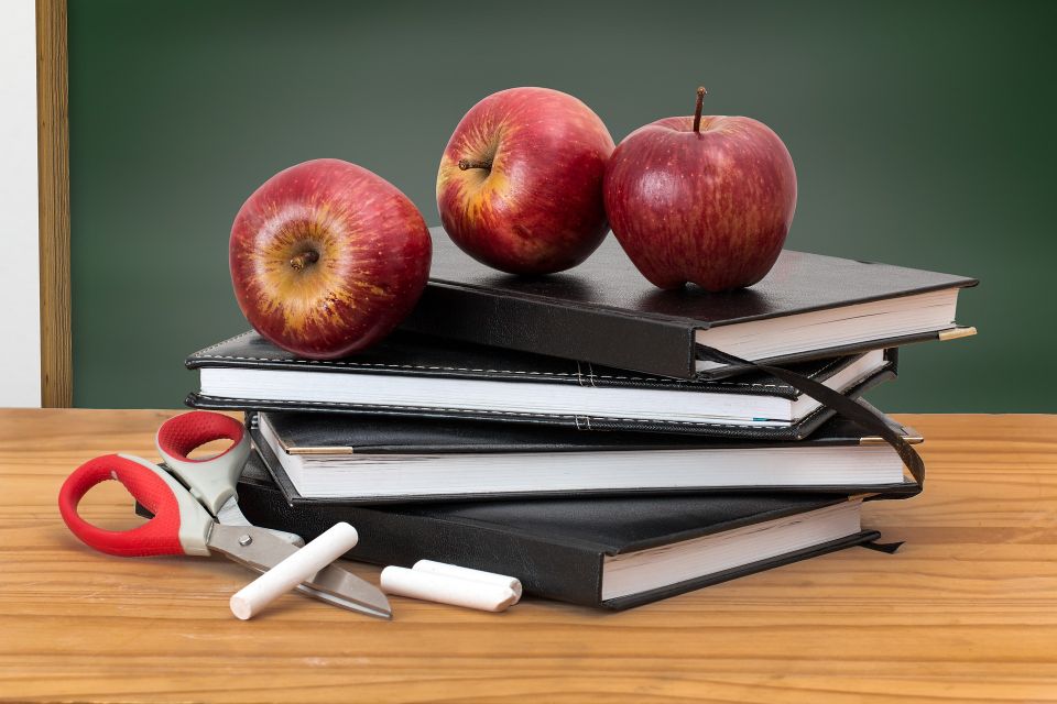 Apples and books on a desk.