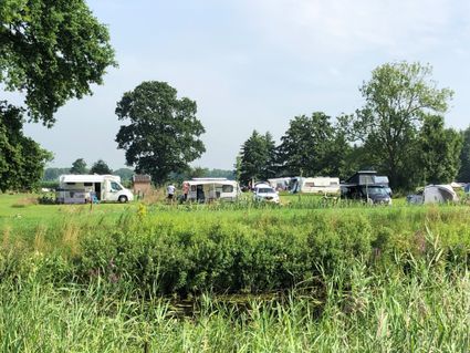Een groen veld met campers en caravans