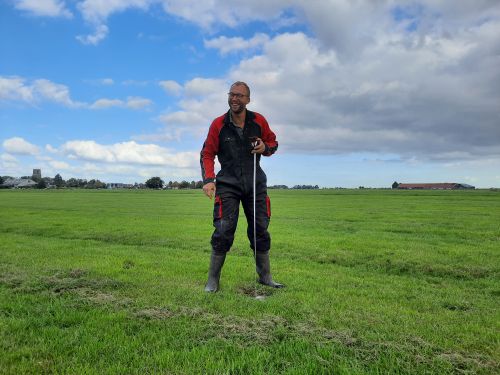 Boer Tom Huitema meet het grondwaterpeil in zijn weiland
