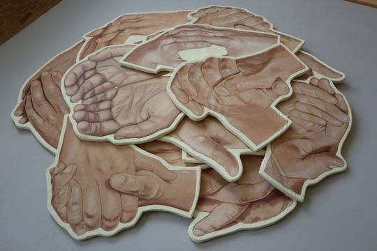 Een kunstwerk bestaande uit verschillende handen die elkaar 'uithelpen' gemaakt door Sara Bachour