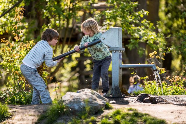 Twee kinderen spelen met waterpomp in Speelnatuur van OERRR 's- Graveland