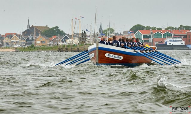 Roeiers in een boot op het water met golven tijdens de Vuurtorenrace Urk in Flevoland