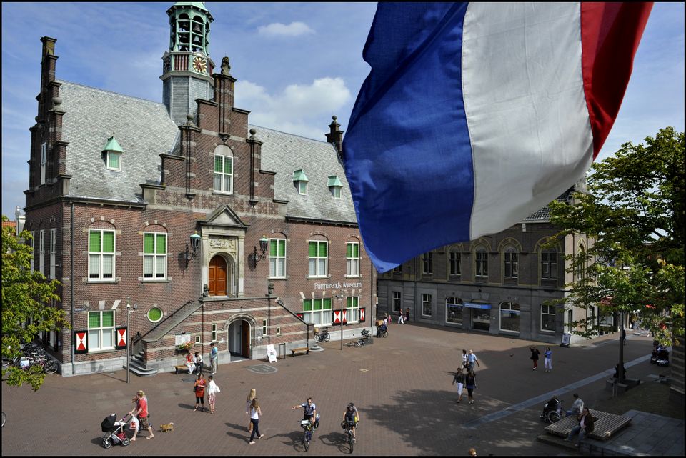 Foto van het Purmerends museum met op de voorgrond een Nederlandse vlag