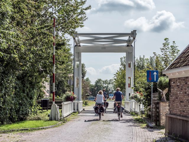 fietsen in een klein dorpje met een wit bruggetje
