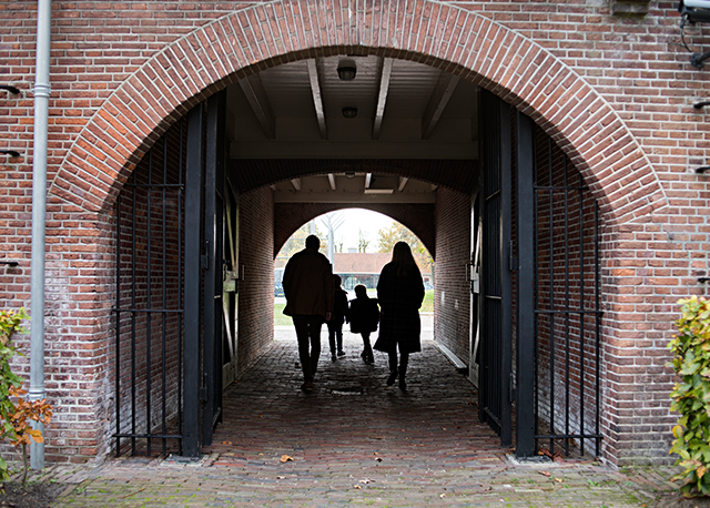 Een gezin loopt door de poort bij het Gevangenismuseum.