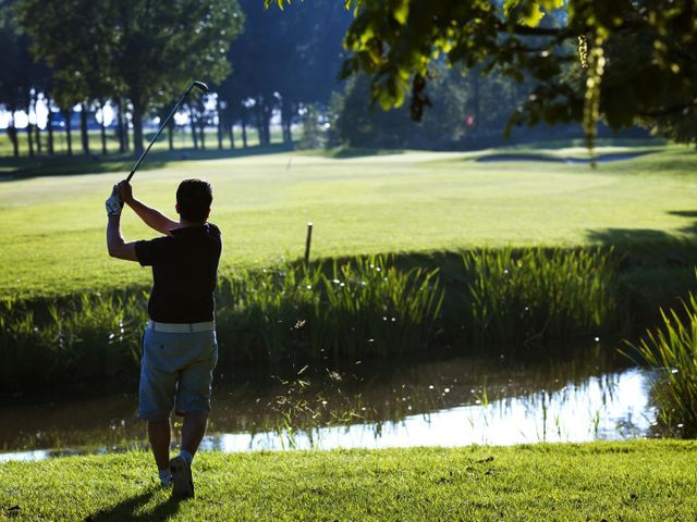Een man is aan het golfen bij Burggolf Westerpark.