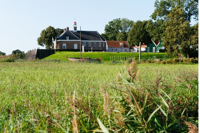 Groot grasveld met uitzicht op museum Schokland en de kerk van Schokland in de Noordoostpolder.