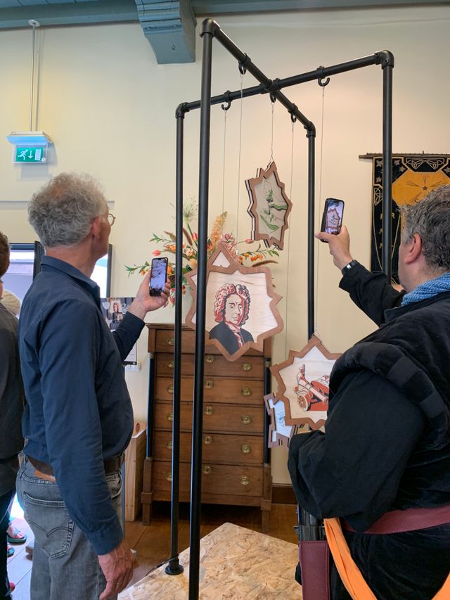 Twee mensen scannen de hangende figuren van het kunstwerk