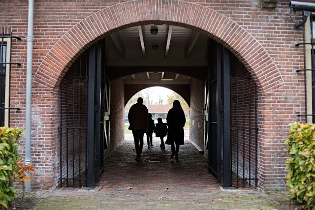 Een gezin loopt door de poort van het Gevangenismuseum in Veenhuizen.