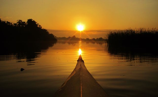 Ondergaande zon water kano