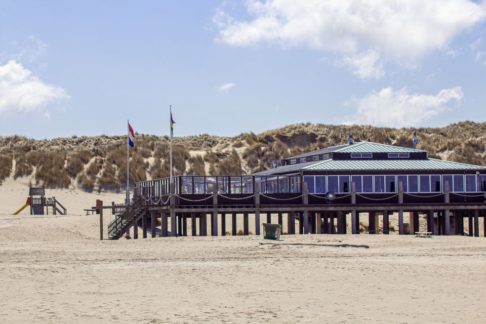 Strandpaviljoen West aan Zee op Terschelling. Strand met duinen en een gebouw