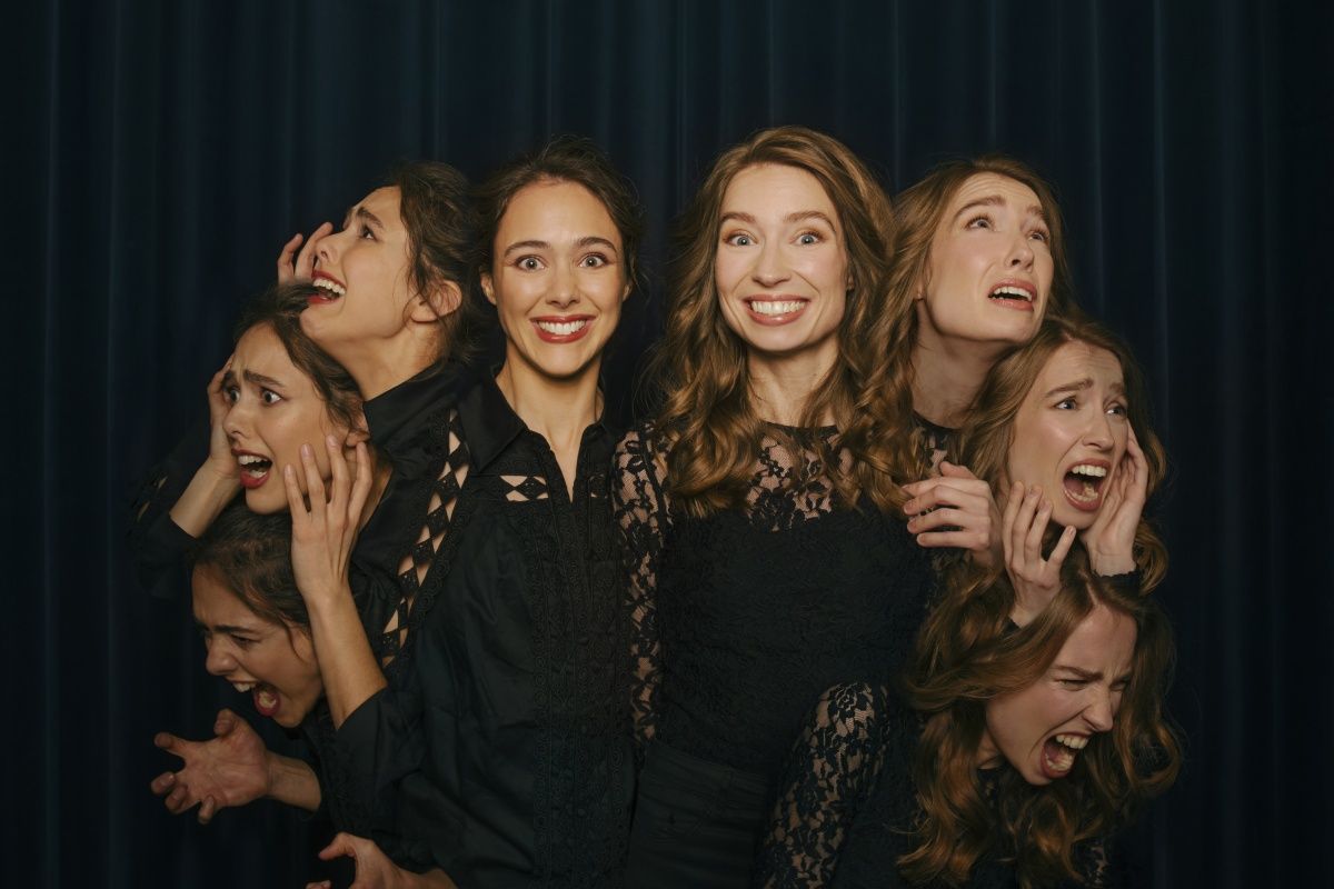 Twee meiden die voor een theaterdoek staan met een grote lach op hun gezicht, daarnaast zie je hun gezichten die verschillende emoties uitdrukken.