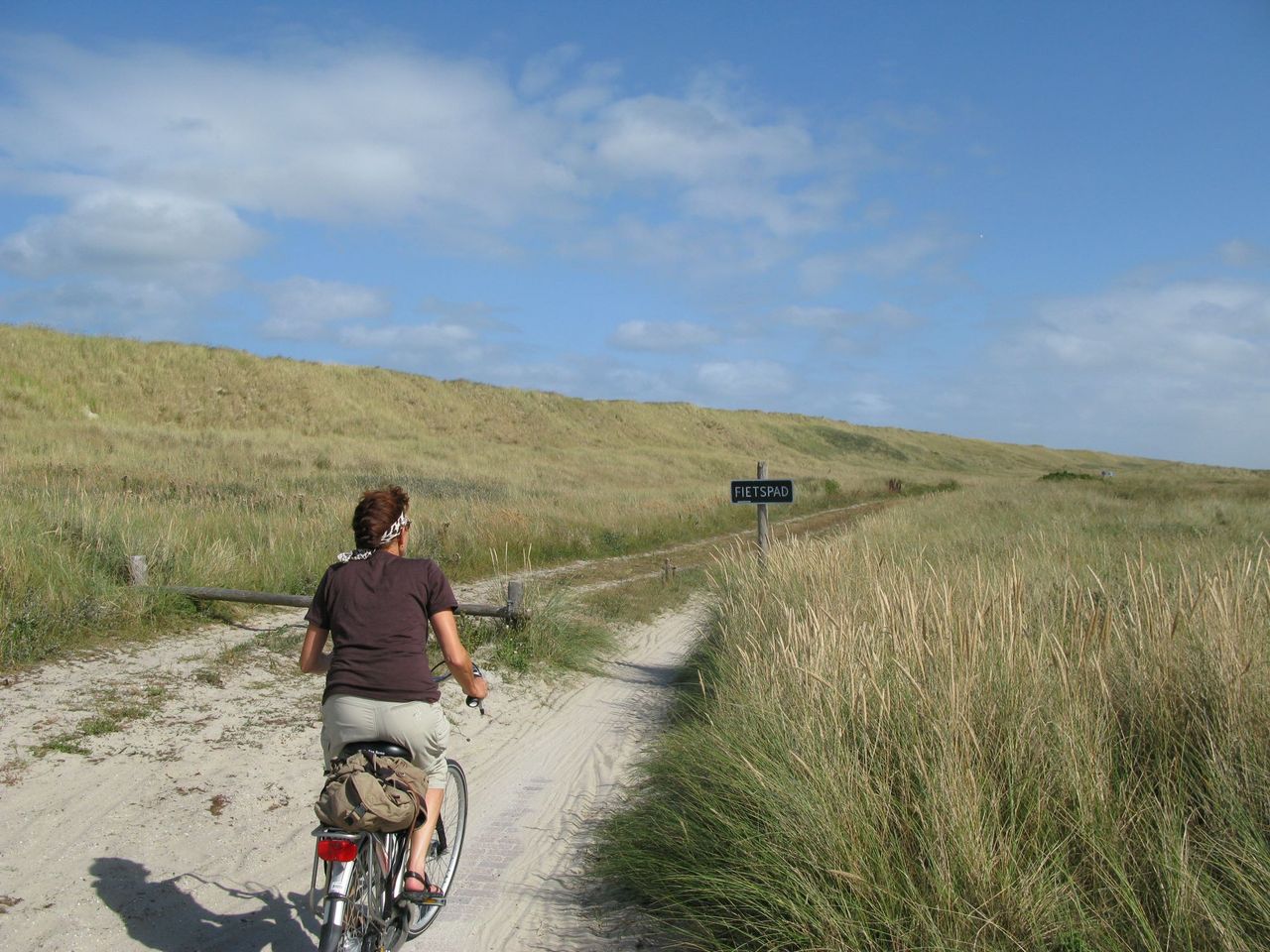 Foto fietsende vrouw in duinen Vlieland (klein)