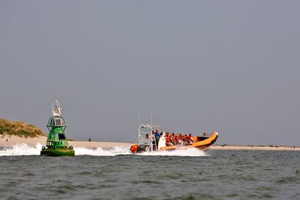 Snelle rubberboot watertaxi bij boei