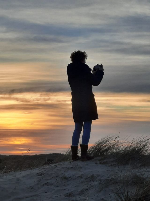 Fotografe maakt foto op duinen van zonsondergang Vlieland