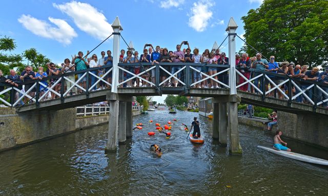 Maarten van der Weijden zwemt onder brug met publiek