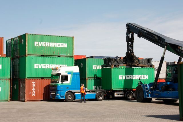 Containers uit de industrie worden verplaatst door een man en machine in Lelystad, Flevoland